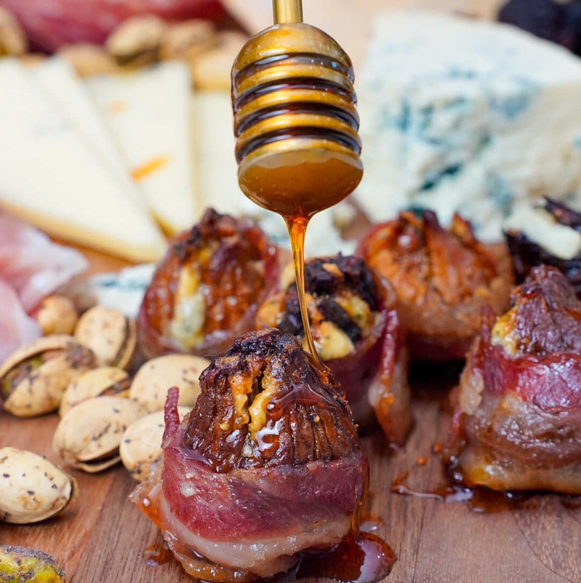 Jump on the hot honey trend with @CoupleintheKitchen's blue cheese-stuffed California Dried Figs, wrapped in candied bacon and dripped in hot honey.